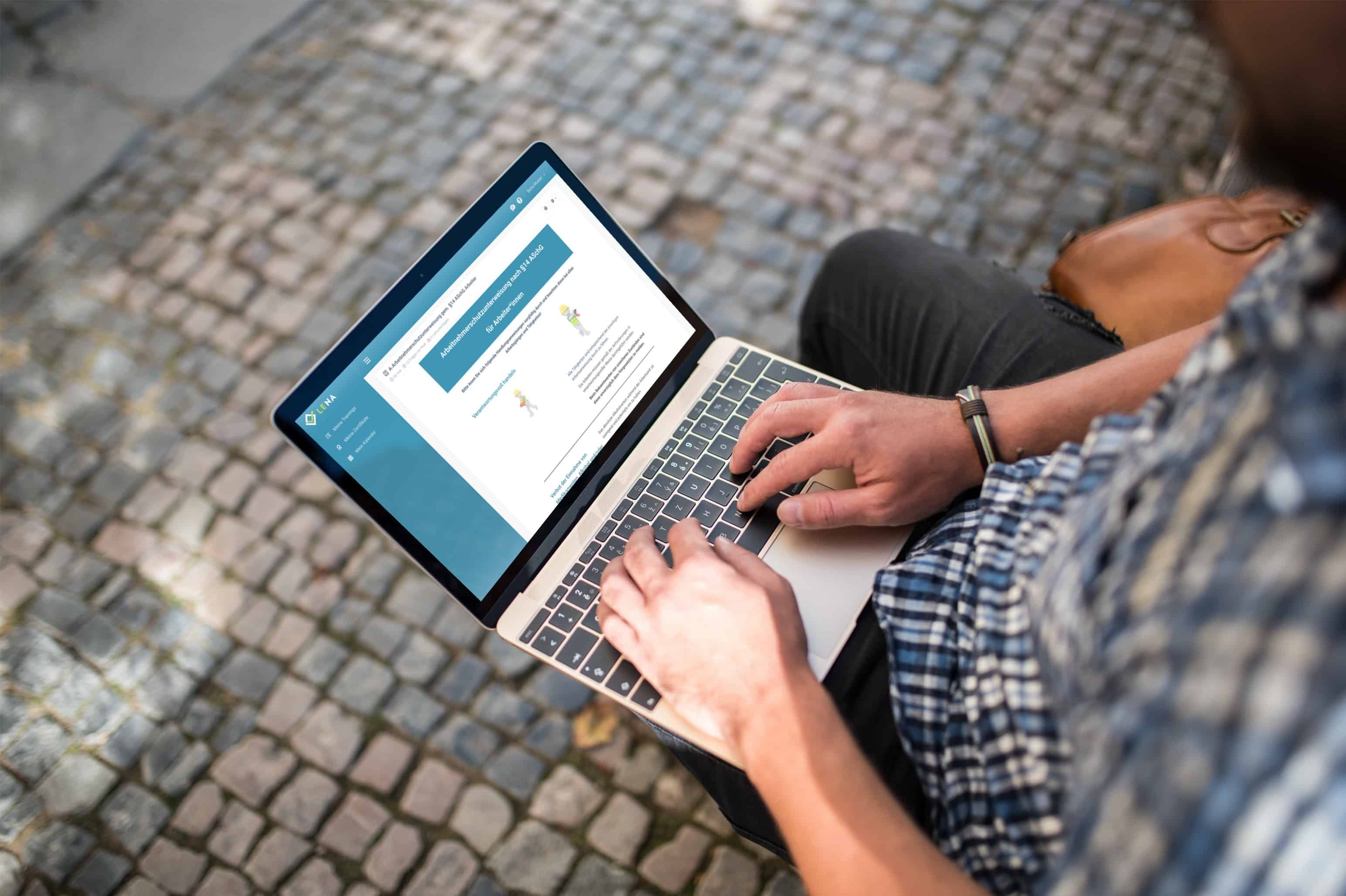arbeitnehmer erledigt eine digitale unterweisung mit laptop auf der parkbank